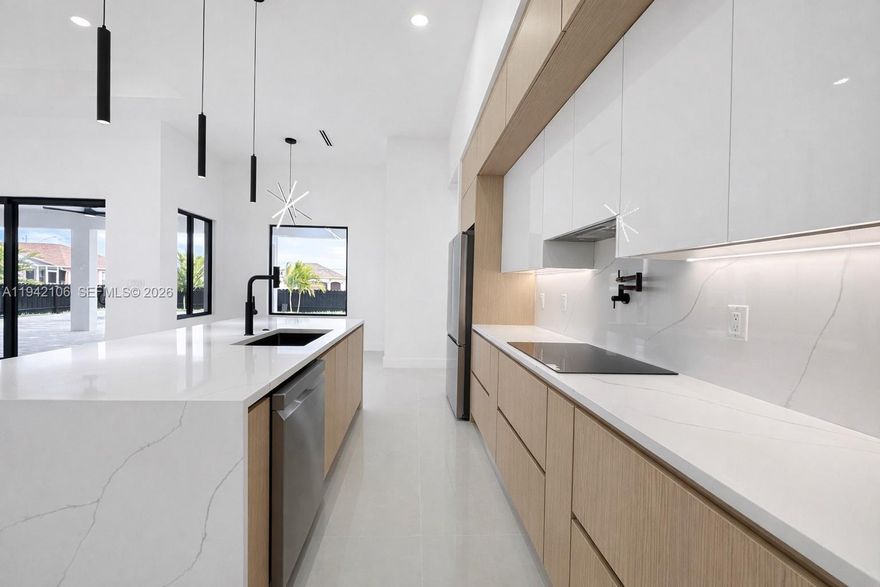 This is the kind of home buyers wait for in Northwest Cape Coral. A true statement property with four bedrooms, three bathrooms, and a three car garage, built with intention and finished at a high level. Clean modern architecture, custom windows, and exterior lighting throughout create instant curb appeal and set the tone before you even walk in. Inside, the home feels open, bright, and refined. Large format porcelain flooring runs throughout. The kitchen is built to impress with custom cabinetry, quartz countertops, top of the line appliances, and LED lighting underneath the cabinets that gives it a sharp modern edge. The oversized island anchors the space and flows perfectly into the living and dining areas. Every bedroom features a walk in closet with built in storage. The primary suite delivers a true spa experience with designer finishes, a spa style shower, and a smart toilet with integrated bidet. Secondary bathrooms match the same modern standard. Step outside to a covered lanai with a modern outdoor barbecue and a 12 x 24 pool, ideal for entertaining or unwinding year round. No HOA. Located in one of the most desirable pockets of Northwest Cape Coral, close to shopping, dining, and major roads.
This home offers design, quality, and location without compromise. Schedule your private showing today.