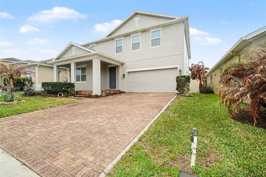 5-bedroom, 3-bath home in Minneola with 2-car garage and two-story layout. Bright living area features wood-style floors and accent wall. Kitchen offers built-in appliances, ample cabinetry, and large island, with adjacent dining area. Sliding doors open to covered patio and paved backyard. Upstairs loft adds flexible space. Near Publix at Hills Crossing, Lake Minneola, Waterfront Park, South Lake Trail, Clermont Landing, US-27, and Florida Turnpike.