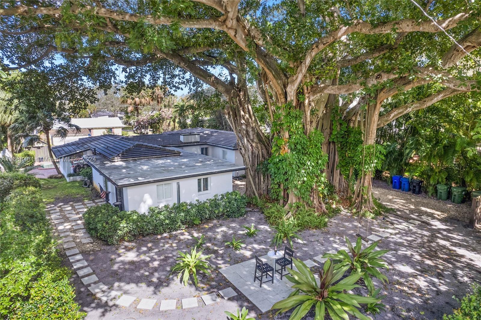 One of the most enchanting homes in the desirable River Oaks community, this unique gem is nestled in a lush tropical locale, featuring a majestic Banyan tree on a spacious double corner lot. The elegantly designed 4-bedroom, 2.5-bath home is ideal for entertaining and boasts a stylish kitchen with a gas range, a coral rock fireplace in the living room & an open layout with views of the serene pool area and tropical surroundings. The living & dining rooms have glass doors opening to the pool and covered patio. The primary suite offers a fireplace, ample walk-in closet & a bathroom with double sinks and shower. Additional features include hurricane windows/doors, skylights & a laundry/storage room. This opportunity is due to seller's international relocation, furniture is negotiable.