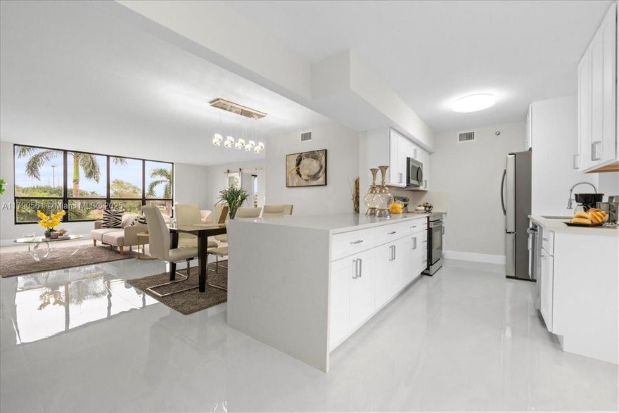 Welcome to this stunning lakefront unit offering 3 spacious bedrooms and 2 luxurious bathrooms. Designed with modern elegance in mind, the home features sleek porcelain tile flooring throughout and a one-of-a-kind contemporary kitchen, highlighted by pristine white cabinetry and exquisite Calacatta quartz countertops. Enjoy the benefits of residing in a prestigious country club community, with the flexibility of optional membership. Perfect for those seeking style, comfort, and a remarkable lifestyle, this residence is truly a rare find.
