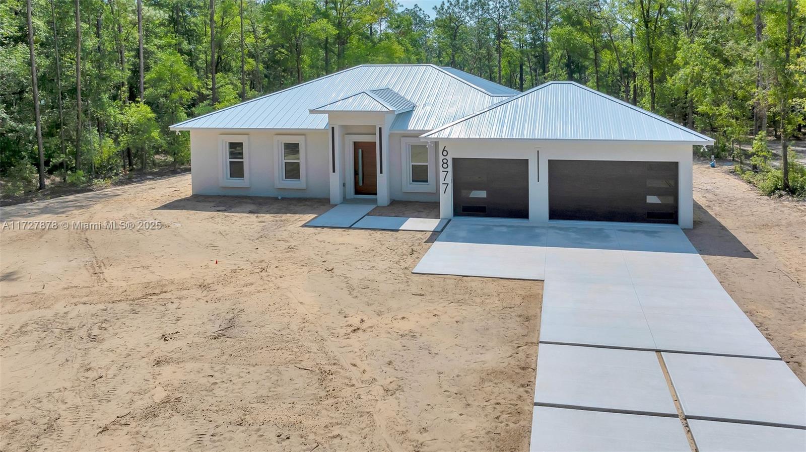 ICF-INSULATED CONCRETE FORMS-HOME that offers improved energy efficiency, thermal insulation, hurricane resistant, acoustic insulation with impressive strength and reliability. This is a New Spec Home for the growing Ocala area. Located in Rolling Hills, in a 1.54 acres lot with 150 ft set back from the main road, this 2,284 sq ft interior living area + 880 sq ft of insulated garage home with standing seam metal roof, has 4 beds/3 baths,open concept kitchen/dining-room/living-room/entertainment area,large laundry room,3 vehicles garage.High ceiling of almost 11' tall and 4'x4' polished tile throughout the entire house,custom designed kitchen w/granite island/countertops,double oven,refrigerator,wine cooler,induction cooktop,downdraft ventilation system,Washer/Dryer.Irrigation system.