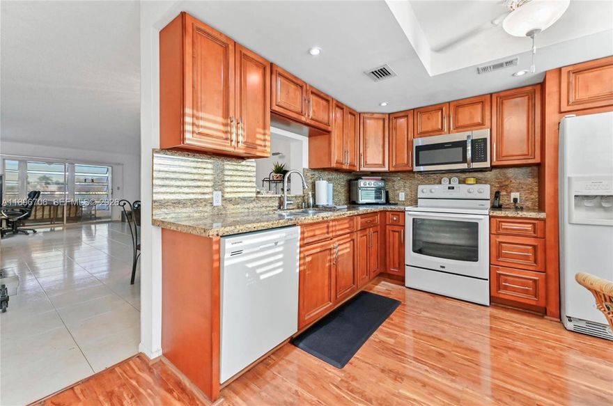 2BR/2BA condo in sought-after Wynmoor Village! Ready for your touch, the hard part is already done. Enjoy an open, sun-filled layout with clean white tile floors, an updated kitchen with granite counters & solid wood cabinets, and a spacious enclosed patio overlooking Hole 1 on the golf course & lake view. Primary suite features walk-in closets & patio access. Resort-style 55+ community with golf, pools, tennis, pickle ball, fitness, theater, café, and endless clubs & events. Minutes to shopping, dining & highways, country club living at an unbeatable value!