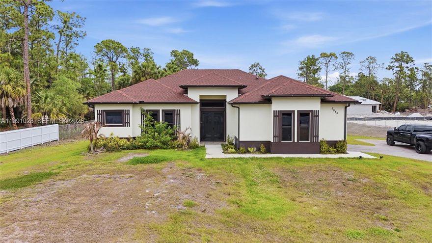 Golden Gate Estates home on 2.75 acres featuring a split-bedroom layout, a spacious kitchen with ivory soft-close cabinets and beautiful countertops, plus a office room. Enjoy high ceilings and recessed lighting throughout. The property offers a large covered patio, garage, and a fully fenced lot with a private entrance. The grounds have been prepared for parking—perfect for an RV, boat, or semi-truck. Impact windows throughout for added security and efficiency.