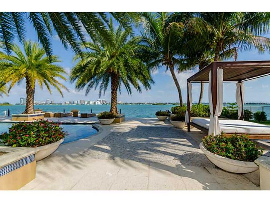 Grand estate with 150 FT on open bay! This waterfront estate sits on 22,500 SF lot w/ 9,000 SF (per appraisal) of interior luxury. Features include: entry w/ double volume ceilings; huge gourmet kitchen w/ gas stove; family room w/ wet bar; movie theater;  billiard room; gym; & wine storage. There is a huge master suite with sitting area & walk-in closet. The outdoors is a one of a kind paradise w/ heated pool, summer kitchen, wood burning pizza oven, guest house, children playground, dock  & boat lift.