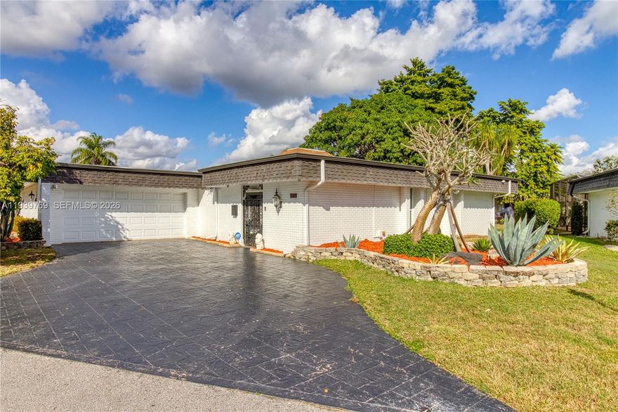 Light-filled single-family home with a brand-new roof and impact windows in Woodlands of Tamarac. Situated on a 10,000+ square-foot lot with native plants and fruit trees, the exterior feels like your own tranquil retreat. Inside, the home features expansive, open living areas highlighted by vaulted ceilings and large impact sliding glass doors that create a bright, airy atmosphere and seamless indoor-outdoor flow. Enjoy the oversized enclosed patio/Florida room, ideal for entertaining, relaxing, or creating additional flex space such as a home office, studio, or game room. Great parking or storage in the large two-car garage. Low HOA fee includes lawn care. Conveniently located near shopping, dining, and major roadways, this home presents great value for the size, location, and superb condition.