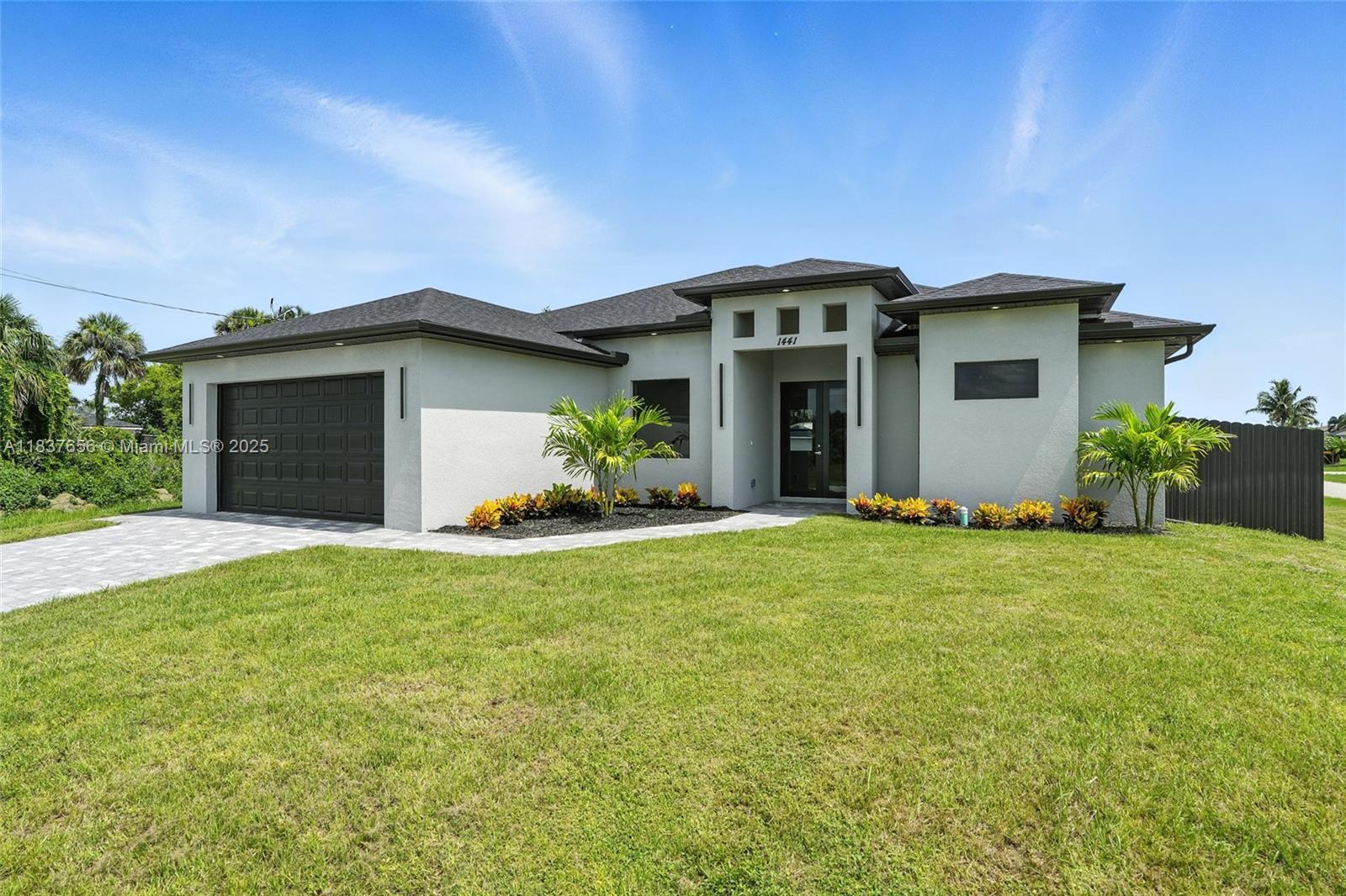 Stunning new construction home located on a desirable corner lot in Cape Coral. This 3-bedroom plus den residence offers nearly 1,800 sq. ft. of living space with elegant flooring throughout (no carpet), high-end light fixtures, quartz countertops, and designer ceiling fans. The open-concept layout connects the gourmet kitchen to the living and dining areas, leading to a full outdoor kitchen—ideal for entertaining. A cozy built-in fireplace adds warmth and charm. The den provides flexibility for a home office, guest room, or hobby space. Additional features include a tile roof, paver driveway, impact-resistant windows, washer and dryer included, and a fully fenced yard offering privacy and security. Located in a non-flood zone with no HOA
