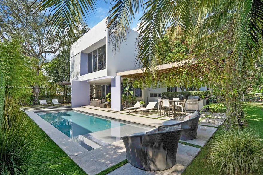 Designed by renowned architect Roney Mateu, this breathtaking 4-bed, 4.5-bath modern home is a masterpiece of contemporary living. Interiors by Ananda Spaces feature soaring 20-foot glass walls, custom art lighting, and exquisite built-ins. The MiaCucina kitchen boasts Wolf and SubZero appliances, while the luxurious primary suite offers a private sitting area, an oversized closet, and a spa-inspired bath. Lush tropical greenery surrounds multiple covered terraces, a sparkling pool, and a summer kitchen—perfect for relaxation or entertaining. Situated on an expansive 15,000+ square foot corner lot, this stunning property is designed to impress. Ideally located near top schools, Dante Fascell Park, and charming boutiques and cafes, this home is the ultimate live-work-play retreat.
