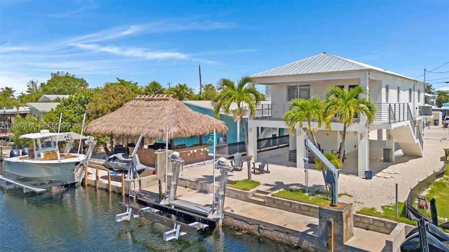 Experience refined waterfront living in this move-in-ready coastal retreat, ideally located on the bay side of Key Largo within a desirable boating community offering direct access to open water. This 3-bedroom, 2-bath residence is built with solid concrete block construction (CBS), completed in 2020 and tastefully renovated in 2021, blending modern design and timeless coastal elegance. The gourmet kitchen features premium Viking and LG appliances, including a 36" gas range, wine cooler, drawer-style microwave, pull-down faucet, and quartzite countertops. Outdoor living defines the Florida Keys lifestyle with a 40-foot concrete dock and 5,500-lb davit, ideal for boating and fishing. A private swimming pool is currently being installed, along with a perimeter fence for added privacy, both included in the price. Additional highlights include 9-foot ceilings, a metal roof, tile flooring, impact windows and doors, central air conditioning, ceiling fans, and a covered garage for up to four vehicles with trailer space, creating the perfect setting for relaxed bayfront living.