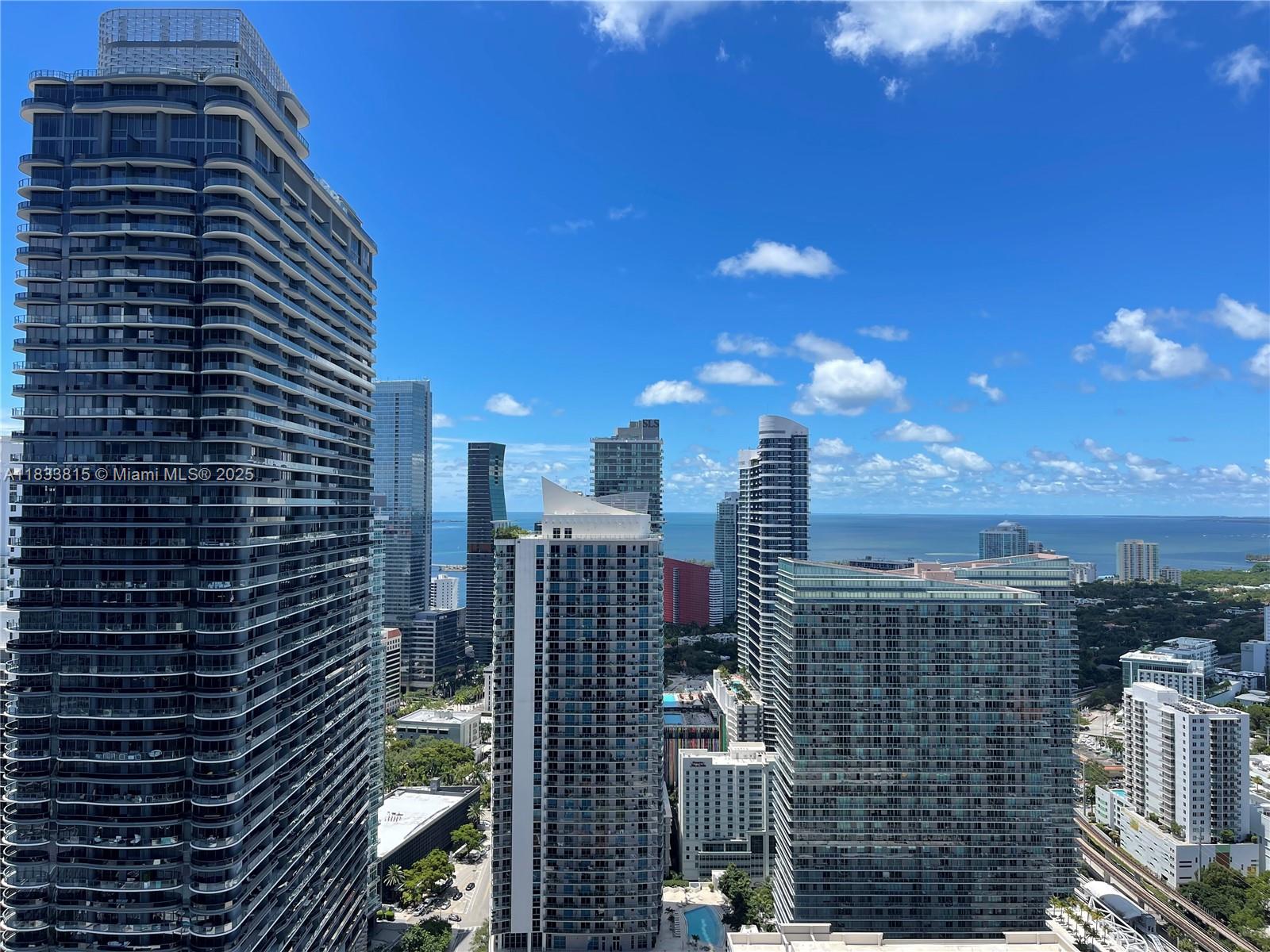 Step into sophisticated city living with this stunning 1-bedroom plus den, 2-bath residence featuring one of the most desirable floor plans in the tower. One of only five in its line, this unit rises above the building across the street, offering spectacular, unobstructed south-facing bay views — a rare vantage point few enjoy.
Inside, the thoughtfully designed layout is enhanced by higher ceilings, creating an even greater sense of space and light. The welcoming foyer opens to an expansive living area with floor-to-ceiling windows that frame breathtaking bay and city views.
At the heart of the home, the gourmet kitchen is an entertainer’s dream, equipped with premium Bosch and Sub-Zero appliances and flowing seamlessly into the spacious open-concept living and dining areas.