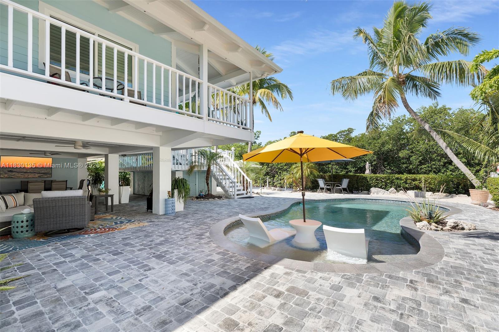 This is the Florida Keys lifestyle done right! Located just 4 homes from open water, this elevated home offers instant Gulf access and a resort-style backyard that steals the show! Enjoy 100 ft. of private waterfrontage with no neighbors across the canal(undevelopable-buyer to verify), a 70 ft. maintenance-free composite dock and a tiki hut right on the water's edge. The private backyard oasis features a heated & chilled concrete pool, elevated hot tub deck with canal views, firepit, lush landscaping plus a shaded patio for poolside lounging. Inside, the home is bright, spacious and open with soaring vaulted ceilings throughout including all three bedrooms and the oversized master bath. Take advantage of seamless indoor-outdoor living with multiple access points from the home