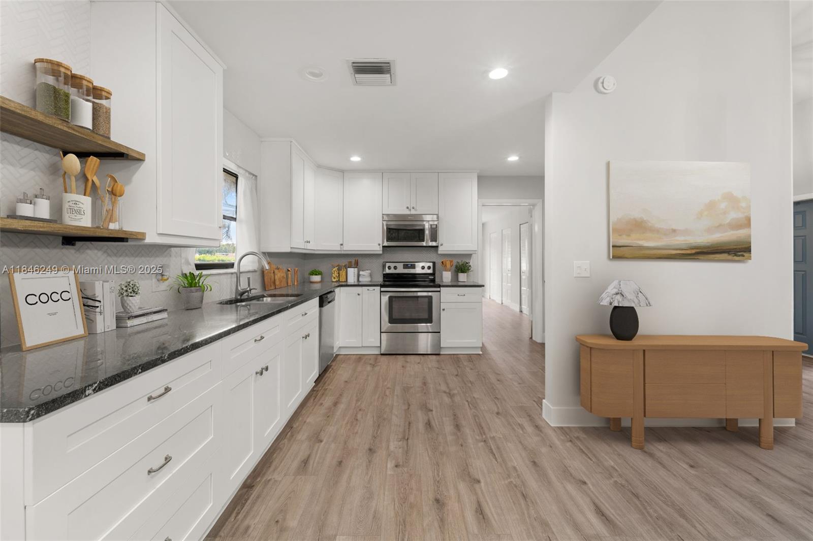 The updated kitchen steals the show with white shaker cabinets, striking black granite with white veining, herringbone tile backsplash, open shelving & stainless steel appliances. New waterproof vinyl flooring throughout and fresh finishes make this 3-bedroom home move-in ready. Set on one of the largest lots in Rainberry Bay, it offers a large open floor plan, vaulted ceilings in the vibrant 55+ community. 3rd Bedroom can also be used as an office or exercise room. Plantation shutters in primary bedroom. Guard gated community. Roof 2024, AC 5 yrs. Enjoy resort-style amenities including 5 pools, 12 har-tru tennis courts, pickleball, fitness facility, 900 seat theater, scenic walking paths and more—just minutes from Atlantic Ave and the beach. NO pets. Must own for 2 years before renting.