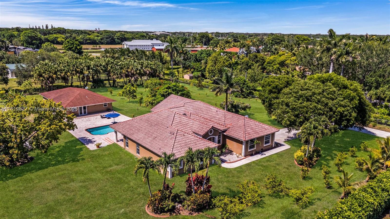 Enjoy privacy on this amazing, fully fenced and gated 2.2-acre estate in equestrian-friendly Southwest Ranches. Great opportunity to own this retreat featuring a 5-bedroom main residence and a separate 2-bedroom guest house-perfect for multi-generational living, extended guests, a home office, or rental income. The main home offers over 3,000 sq ft of living space, volume ceilings, abundant natural light, 2-car garage, and expansive driveway. The detached, updated guest house boasts over 1,300 sq ft, a storage room, private laundry, and a 3-person jacuzzi. Property features new water heaters, new well pumps and water filtration systems. Located in rural Sunshine Ranches with nearby access to highways, this estate enjoys agricultural exemption with citrus, tropical, and exotic fruit trees.