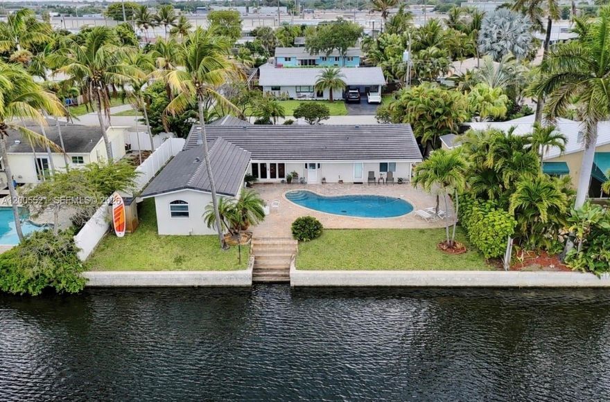 Wake up to a beautiful waterfront breeze every morning in this resort-style pool home with NO HOA, just 5 minutes to the beach. This 4-bedroom, 3-bath residence offers a 2-car garage and circular driveway with ample parking. Major upgrades already completed, including a NEW concrete tile roof, NEW A/C,  impact windows and doors. Tankless water heater and New washer and dryer. Enjoy true waterfront living with one of the longest, most tranquil water views—kayak, boat, or park your boat right in your backyard along your private seawall. Entertain in the kitchen while seeing your guests in the pool. The spacious outdoor area features a large green space perfect for entertaining, grilling, or relaxing poolside. Inside, the open layout showcases porcelain tile flooring with a wood-look finish, an eat-in kitchen, formal dining, and generous living areas. A cozy fireplace and gas cooktop add both comfort and functionality. The primary suite includes a custom walk-in closet and a spa-like bathroom with soaking tub, separate shower, and serene water views. Ideally located near top private schools including Pine Crest, Westminster Academy, and Calvary Christian Academy. Near top rated cuisine Thai Spice, Tequila Sunrise, Publix and local favorites like Funky Buddha Brewery and Jaco Pastorius Park. A rare opportunity to own waterfront living with NO HOA—relax, fish, and enjoy Snook, Tarpon, Jack, and Snapper right from your backyard.