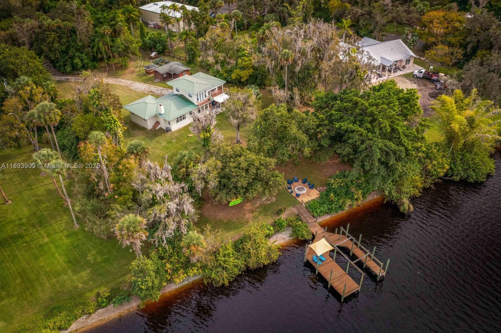 Beautiful direct riverfront 2043 sf home on a 3,4 acre lot, secluded country feel along the scenic Caloosahatchee River. An ideal vacation retreat or your perfect year-round sanctuary. Two suites, a 1/2 bath, and a large loft, used as a 3rd bed. Outside a spacious insulated laundry room. A Covered lanai and game/barbecue area extend the entertainment space. Approximately 180 feet of riverfront on an 800-ft-deep lot, surrounded by nearly 2 acres of woods and pathways perfect for walks, biking. Previous owner expanded and fully remodeled the original concrete block house. 432 sq ft workshop / shed. Spacious 632 sq ft Y-shaped dock, where you can swim, kayak, paddleboard, or simply soak up the sun. On cooler days, gather around the riverfront firepit. This is truly an entertainer’s paradise.