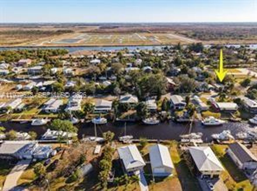 Enjoy true waterfront living on a deep-water canal with direct dockage for your boat. This 2-bedroom, 1-bath mobile home offers comfortable interior space paired with exceptional boating access. Two docks provide flexibility — one accommodates a sailboat, while the second offers additional docking potential (in need of repair). Inside, the home features a functional kitchen with gas stove, built-in microwave, double-door refrigerator, deep double-bowl sink with modern spray faucet, attractive backsplash, built-in pantry with sliding doors, wood cabinetry, deep cabinet drawers, and a custom buffet with wall-mounted bookshelves. Accent lighting and an open pass-through connect the kitchen to the spacious enclosed Florida room. The Florida room includes two ceiling fans and French doors that open to a patio overlooking the canal and boat dock. The outdoor patio is enhanced with sun sails for shaded relaxation, creating an ideal setting to enjoy the waterfront lifestyle. A single exterior door provides convenient access to the laundry/workshop shed. Additional highlights include central air conditioning and a screened front porch with roll-down curtains and decorative chandelier. This property offers affordable canal-front living with both indoor comfort and the outdoor access boating enthusiasts seek