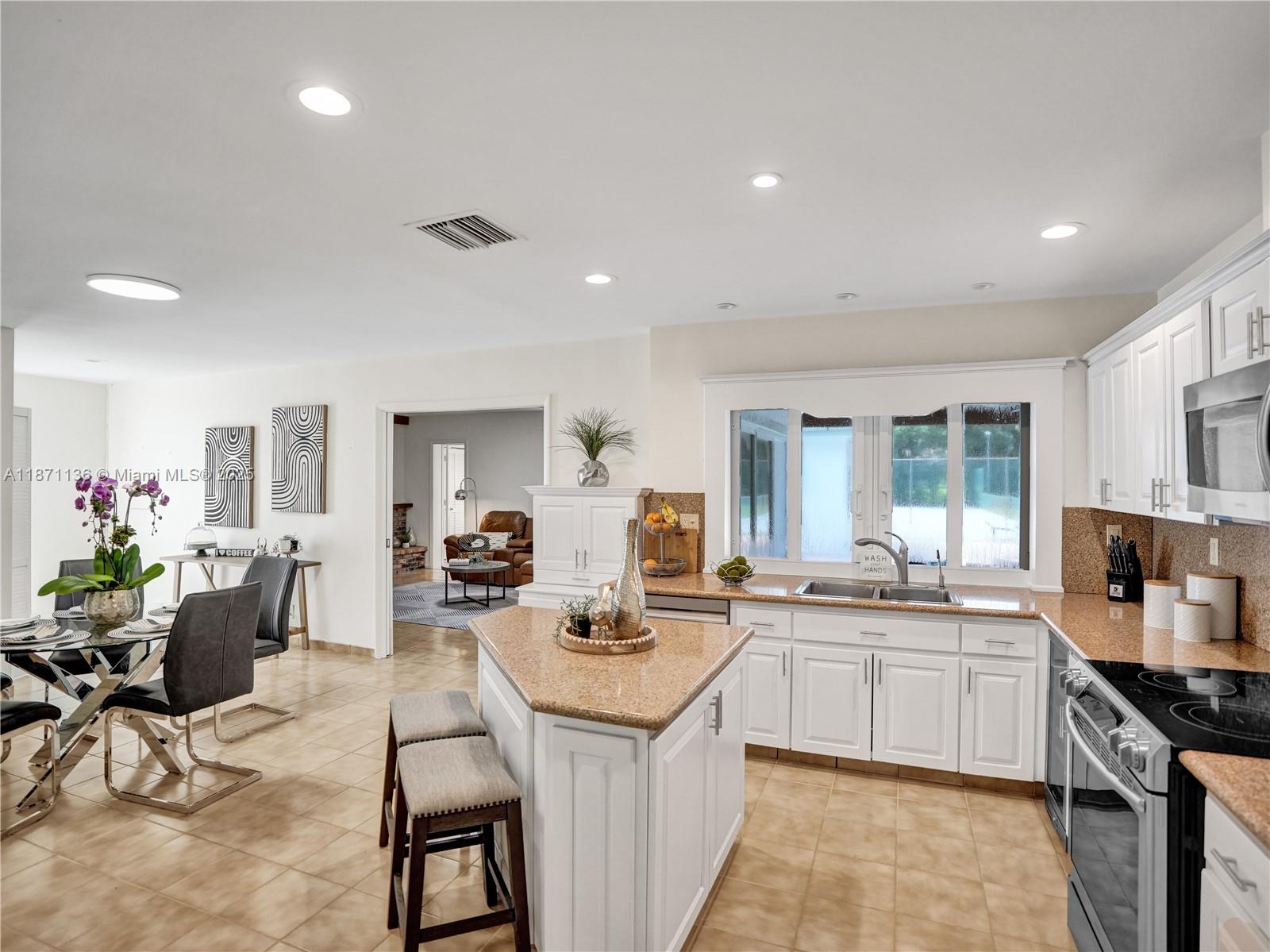 Plantation Acres. Walk into a sunny foyer, large living area & screened patio in lush landscaping. Granite kitchen counters, wood cabinets, new fridge & dishwasher. Reverse osmosis water & whole-home carbon filtration system. Pool area with built-in bar, new awnings, plenty of space for entertaining. Fireplace in the Family room. 5 Bedrooms; 2 on-suites, office, workout room & 2 cabana baths.
A lit, hard-surface court; easily converted to tennis, pickleball, basketball, or hockey. New 2025 tile roof, full impact windows & new impact doors, 3 A/Cs, 2 water heaters, fresh paint & color-tunable LED lights. Smart conveniences: CCTV security with 8 cameras, central vacuum, EV charger & pool-house storage. Large circular drive & 2 car garage. Just 1 mile to American Heritage. Are you ready?