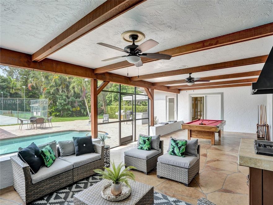 Plantation Acres. Walk into a sunny foyer, large living area & screened patio in lush landscaping. Granite kitchen counters, wood cabinets, new fridge & dishwasher. Reverse osmosis water & whole-home carbon filtration system. Pool area with built-in bar, new awnings, plenty of space for entertaining. Fireplace in the Family room. 5 Bedrooms; 2 on-suites, office, workout room & 2 cabana baths.
A lit, hard-surface court; easily converted to tennis, pickleball, basketball, or hockey.  New 2025 tile roof, full impact windows & new impact doors, 3 A/Cs, 2 water heaters, fresh paint & color-tunable LED lights. Smart conveniences: CCTV security with 8 cameras, central vacuum, EV charger & pool-house storage.  Large circular drive & 2 car garage. Just 1 mile to American Heritage. Are you ready?