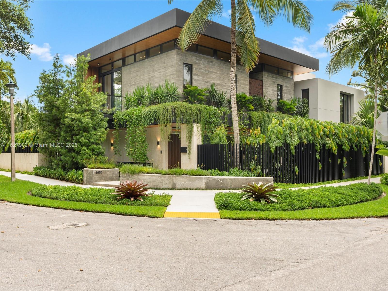Experience the epitome of luxurious living at its finest, just minutes from Cocowalk and top private schools in Miami. This tropical residence seamlessly integrates indoor and outdoor spaces with impeccable design. Enter through an impressive pivot door and be captivated by a stunning water feature. Inside, discover lush hanging gardens, elegant limestone and wood floors, Oolite cladding, and crafted walnut stairs. Bamboo ceilings and bespoke lighting fixtures add to the ambiance. The house boasts 5 bedrooms, 6 baths, a chef's kitchen with Miele and Wolf appliances, and a luxurious primary wet room. Relax in the shimmering mosaic pool with sunken spa and Alfresco BBQ area. This exceptional residence features cutting-edge smart home features, an elevator, and meticulous attention to detail.