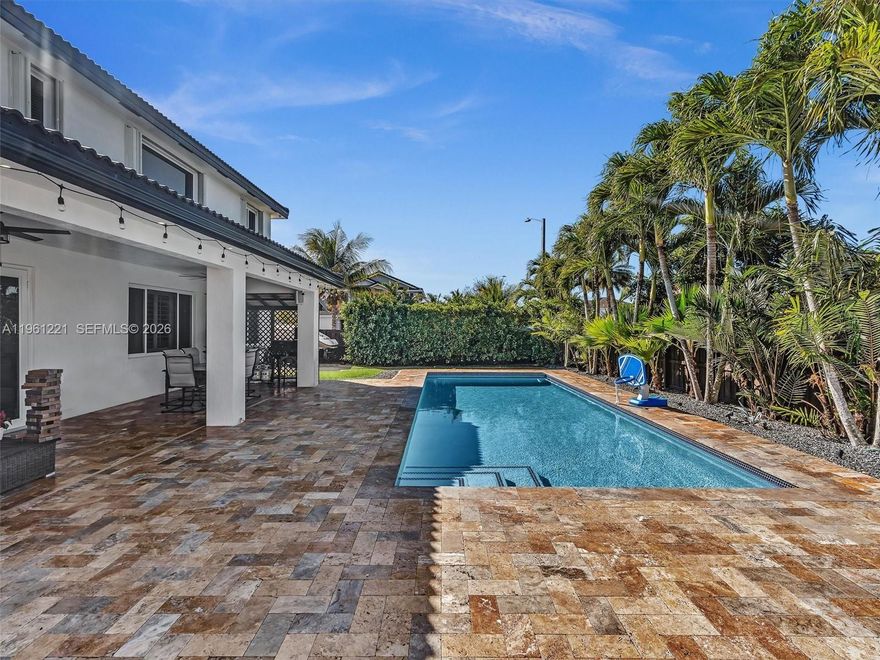 Welcome to this exceptional corner-lot residence offering 5 bedrooms and 3 full bathrooms, including a full bedroom and bath on the main level—ideal for guests or extended family. Bright and airy, the home features quartz countertops, all-wood cabinetry, a large pantry, wood-look porcelain flooring throughout, and plantation shutters. Custom closets elevate the main bedroom spaces. Step outside to your private oasis featuring a sparkling pool, travertine pavers, playground, and included shed. The expansive circular concrete driveway allows parking for multiple vehicles. Enough space to fit a RV and boat. Accordion shutters, security cameras, and full exterior lighting add peace and comfort. No HOA