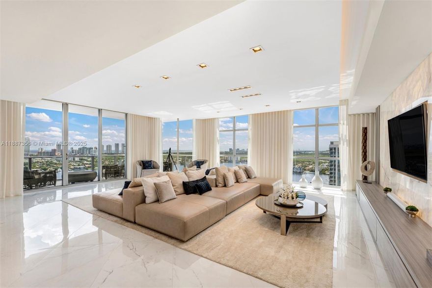 Extremely rare opportunity to own the southeast corner double-unit penthouse in the 5-star luxury yacht club—Marina Palms! Fully furnished and designed by Steven G., this mansion in the sky features every conceivable luxury, service, and amenity one could desire. Finished with the highest quality materials and craftsmanship, it looks barely lived in. Includes four premium main-level side-by-side parking spaces with a private Tesla charger, plus an available 85’ prime boat slip—the epitome of the South Florida lifestyle. Enjoy stunning panoramic views through floor-to-ceiling wraparound glass, double oversized balconies, a chef’s kitchen, theater, a luxurious custom walk-in master closet, and an entire wall of backlit onyx—the ultimate entertaining venue. A true must-see!