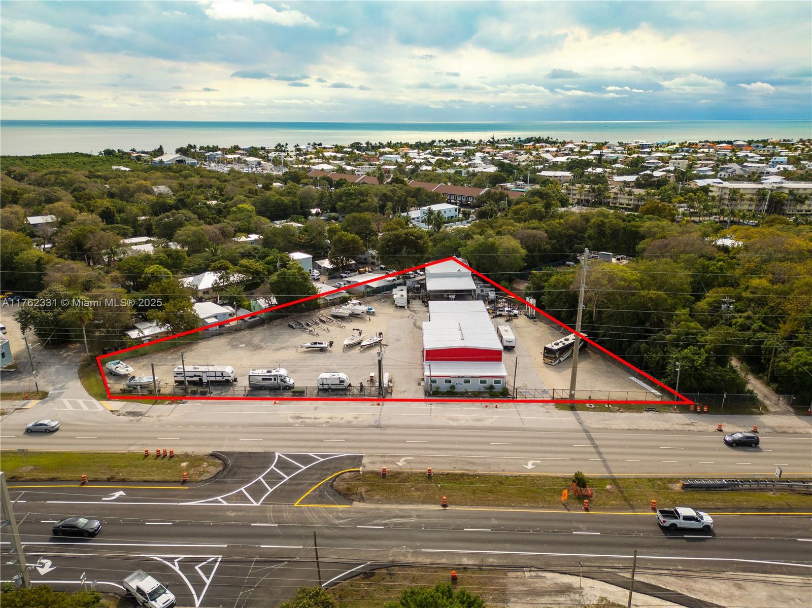 Prime Commercial Property in Key Largo, Just 1 Hour from Miami! This 1.2 acre corner lot with 321 ft of US1 frontage offers unmatched visibility in downtown Key Largo. Fully fenced with 3 new gates (20ft,24ft,40ft), it features a renovated 4,680 sq ft two story building used for RV sales & services. Interior highlights include tile floors, custom desks, ample storage and 2 half baths. Additional features: large paint booth, RV/car lift. Ideal for business expansion or new ventures. High traffic, high potential. Owner open to long term lease.