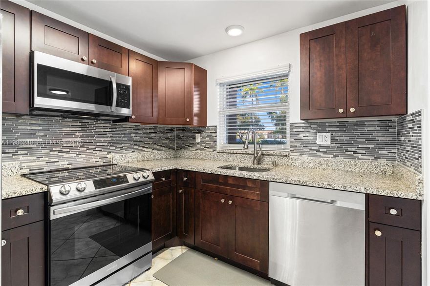 Beautiful spacious pristine updated first-floor unit nothing to do except move in!  Featuring eat-in kitchen with stainless steel appliances, granite countertops, high shine tile flooring throughout, and plenty of natural light.  Enjoy the Florida Room with extra windows and a picturesque serene lake and fountain views. Features include hurricane impact windows, new AC, and 3 closets in the primary bedroom. Located in an active 55+ community with resort-style amenities including heated pools, golf, tennis, pickleball, fitness centers, clubhouse, shows, activities and more. Close commute to airport and major routes of transportation
