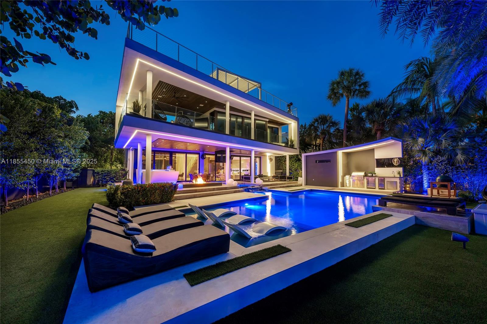 This striking modern tri-level waterfront residence blends bold architecture with refined luxury. Set on a 17,676 SF gated lot w/approx. 90FT of WF, the home offers 9,424 total SF with 5BR/7.5BA, expansive family, dining, & living areas all with water views. Highlights include marble & rich hardwood floors, custom millwork, chef’s kitchen with Wolf and Miele appliances, built-in aquarium, & seamless indoor-outdoor flow. Principal suite features an expansive terrace, spa-style bath, and massive walk-in closet. Additional amenities include a rooftop lounge with firepit & TV, a gym-converted garage, state-of-the-art theater, resort-style pool w/waterfall, summer kitchen, custom bar, 45FT dock, 3 jet ski slips & direct Intracoastal access. This residence epitomizes the Miami lifestyle.