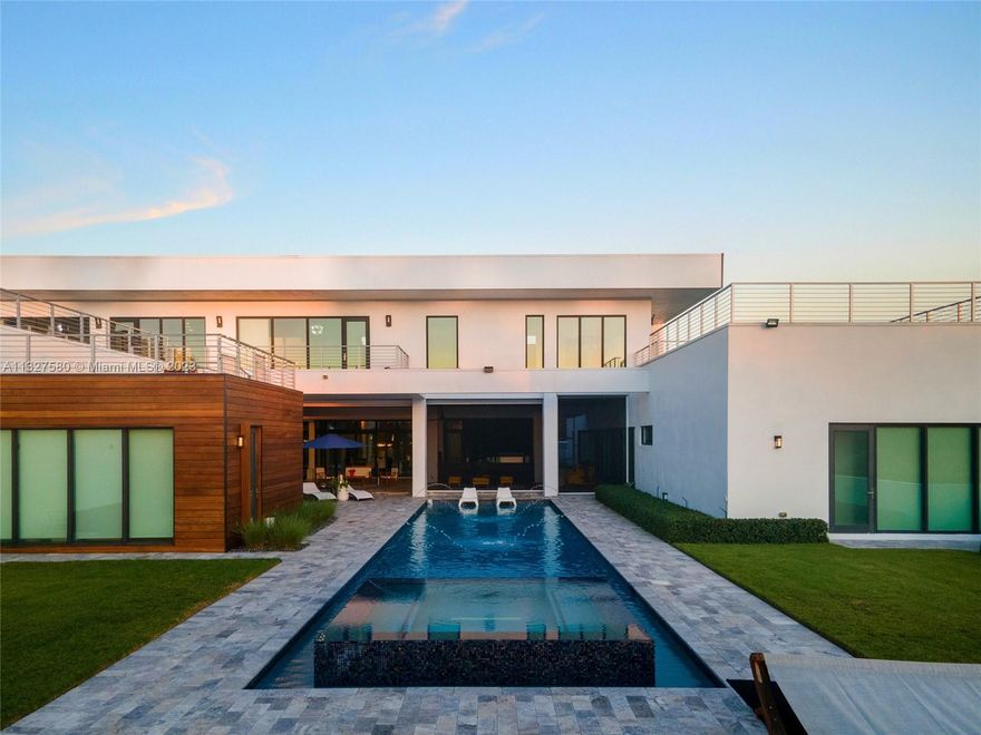 Entertainers delight with nothing left to be desired. Acre of private lakefront property, fully fenced with a heated salt pool, raised spa, and beach entry. Outdoor summer kitchen w/ marble patio w/ electric screens. Lavish in your private 1st-floor owner's suite complete with exercise room/yoga studio, office, and luxurious bath w/ vessel tub, oversized shower, and windows on the water. All additional bedrooms are ensuite, boasting designer materials. Separate guest house with 2 bedrooms, living room, kitchen, laundry, and a 2-car garage. Get ready to entertain! Additional game room/loft on the second level and access to rooftop terraces. European kitchen w/ the finest of amenities. Onyx wall, dual fireplace, full-impact protection, Savant smart home, exterior lighting, and modern design.