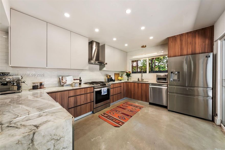 Private retreat in the desirable Sherwood Forest neighborhood of El Portal. This renovated 3BR/3BA home sits on an oversized 8,258 sq ft lot beneath a canopy of mature trees, offering exceptional privacy and natural surroundings.
The 2,090 sq ft layout features high ceilings, refinished terrazzo floors, and wide picture windows that bring in abundant natural light. Updated kitchen with quartz countertops, gas stove, and custom cabinetry, opens to the main living area. Includes a separate guest studio with a private entrance, bathroom, and kitchenette, ideal for guests, a home office, or potential rental income. Solid concrete construction adds durability. Zen-inspired backyard with multiple outdoor living areas and space for a pool. Parking for up to five vehicles with a Tesla charger. Minutes from the Design District, Wynwood, Miami Shores, and the beach.