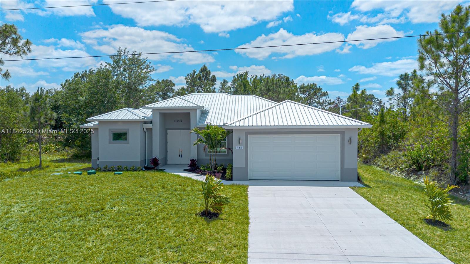 Welcome to this beautifully designed new construction in prime Lehigh Acres, offering quality finishes and a modern layout. This 3-bedroom + den, 2-bath home features 1,717 sqft of living space on a quarter-acre lot. Enjoy an open-concept kitchen with stainless steel appliances, elegant porcelain floors, and spacious living areas. The master suite offers two walk-in closets, dual showers, and a delicate bathtub for a true retreat. Two additional bedrooms and a den provide privacy and flexibility. A stylish metal roof ensures durability, while the 2-car garage and screened lanai with a fully equipped outdoor kitchen add convenience and charm. The private patio offers a serene space perfect for relaxing. Disclosure: Some photos have been virtually staged to showcase the home’s potential.
