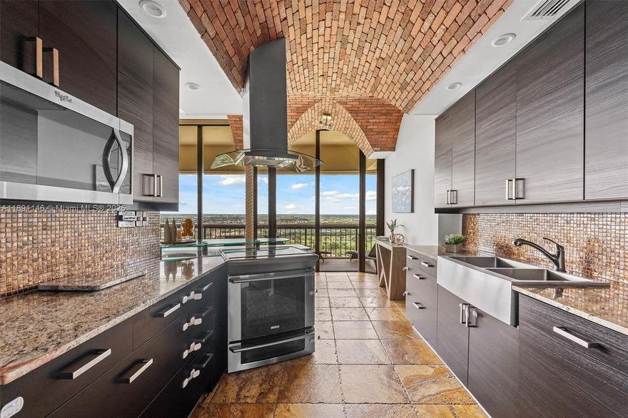 Experience penthouse living with breathtaking golf and city panoramas from a 50-ft balcony. This 2-bed, 2-bath residence spans 1,557 sq ft and blends architectural drama with modern sophistication. The featured vaulted brick ceiling and natural stone floors create a European-inspired ambiance, complemented by a remodeled kitchen with sleek cabinetry, granite counters, and mosaic accents. Spa-style baths showcase designer tile work and custom finishes, while motorized blinds add comfort and convenience. An assigned storage room on the same floor provides useful utility. The Consulate, a full-service tower within The Lands of the President, offers 24-hr security, pool and spa, fitness center, tennis, social room, and more. One assigned covered parking spot and plenty of guest spaces.