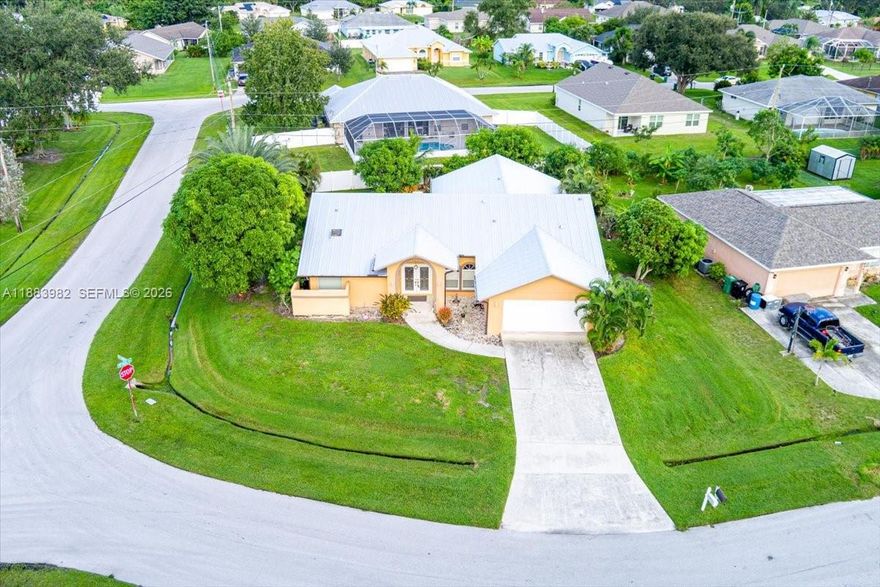 PRICE REDUCTION and 2000 seller credit to buyer at closing. Beautiful MATURE fruit trees. This is a must see. Don't miss the opportunity to own this charming 3-bedroom, 2-bath home in Port St. Lucie, offering comfort and peace of mind with a new metal roof, full impact windows and doors, an A/C from 2019 and water heater from 2022. Featuring a blend of tile and carpet flooring, this home includes a full-size washer and dryer for convenience, high ceilings and skylights. No HOA or vehicle restrictions. Enjoy the spacious screened porch overlooking a large backyard —perfect for relaxing or entertaining. Don’t miss this move-in ready home with plenty of space both inside and out!
