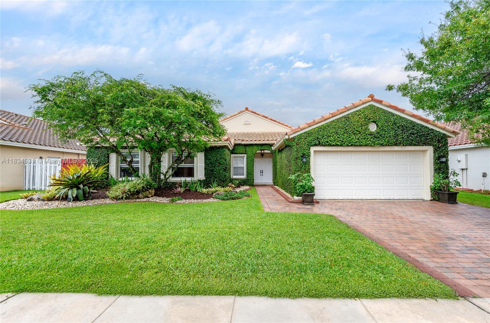 Beautifully updated 4-bedroom plus den/office, 2.5-bath home in the desirable gated community of Encantada. Features travertine flooring throughout the main areas and engineered hardwood in all bedrooms. As you walk in, you're welcomed by a beautiful view of the custom-designed pool. The backyard is perfect for entertaining with a built-in BBQ, lush privacy trees, and a French drain system to help keep the yard dry. The kitchen offers custom cabinetry, granite countertops, and ample storage. Additional features include hurricane shutters, high-impact doors, a Tesla charger, and custom built-ins in the garage for organization. Enjoy low HOA fees and access to community amenities including a pool, playground, basketball and volleyball courts, tennis courts, and a clubhouse. Move-in ready!