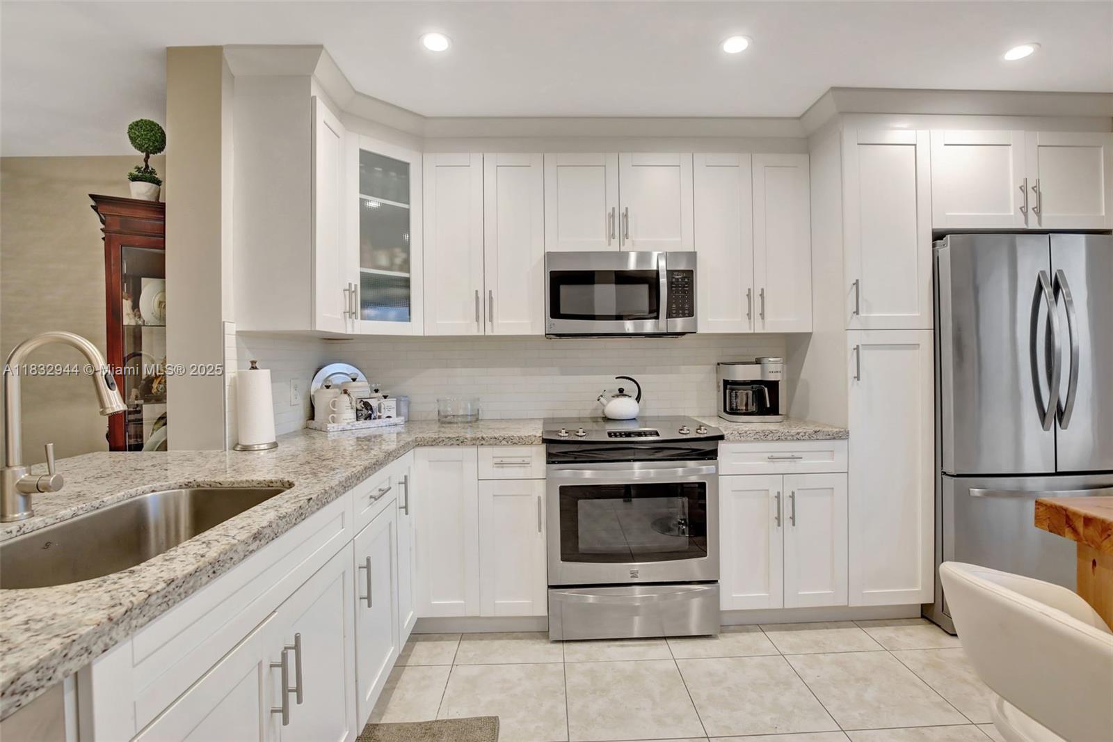 Impeccably upgraded fourth-floor unit featuring two bedrooms and two bathrooms, with all hurricane-impact windows for added security and peace of mind. The modern kitchen boasts contemporary upgrades, including exquisitely designed wood cabinets, granite countertops, and a stylish stone backsplash. The layout includes a bright dine-in kitchen and a spacious master bedroom with a walk-in closet, offering ample storage and convenience. Enjoy the added benefit of attic storage space and durable tile flooring throughout the unit. Relax on the patio while taking in the scenic nature views and beautifully manicured golf course — a perfect spot to unwind and watch the golfers. Include an in-unit washer and dryer, and the satellite pool located directly across from the building for easy access.