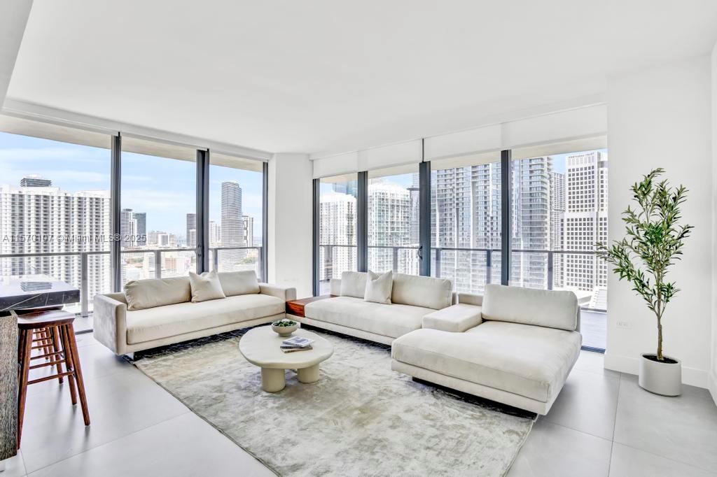 Experience sophistication in this fully remodeled 2-bed, 2.5-bath residence with stunning sunrise views of Biscayne Bay and the city skyline. Designed with elegance in mind, the home features 48x48 Gubi Porcelain tile floors, a modern kitchen with Italian cabinetry, honed marble countertops, Bosch appliances, and a wine cooler. The primary bath is a spa-like retreat, boasting a freestanding tub and striking 120x120 Eco Ceramics wall tiles.
Floor-to-ceiling windows, a wrap-around balcony, and electronic blinds enhance indoor-outdoor living. Just steps from Brickell City Centre, The Rise Condo offers 5-star amenities, including a fitness center, heated pool, valet, Hamman spa, steam room and more.