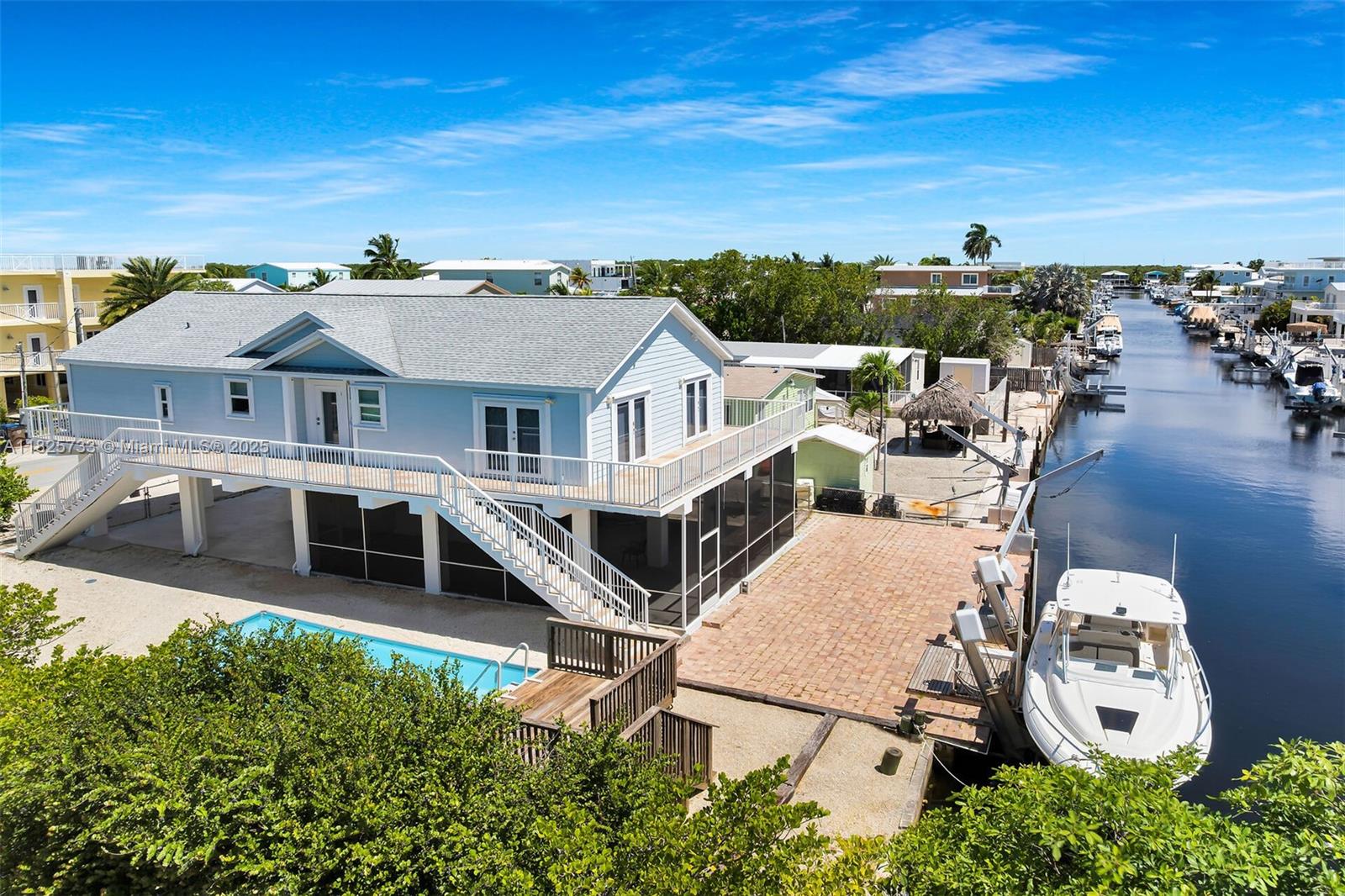 Stunning 3 Bed-2 Bath Key Largo Canal front and Corner Lot with 65 Feet of Concrete Dock!!! 2 Minute access to Blackwater Sound. This impeccable home features all the modern luxuries you could want including Hard Wood Flooring! It's gorgeous!! The open concept living area with high vaulted ceilings is spectacular. Enjoy a fully equipped kitchen with stainless steel appliances and a huge kitchen island for entertaining. Step in the primary bedroom and relax or enjoy a spa like experience in this luxurious bathroom. Downstairs you will find a large screened in room for Fun in the Sun BBQ's. The concrete dock boasts a 15,000 boat lift and davits for all your water toys. Located in Lake Surprise, one of Key Largo's premier neighborhoods. Don't miss the opportunity to own a slice of paradise!
