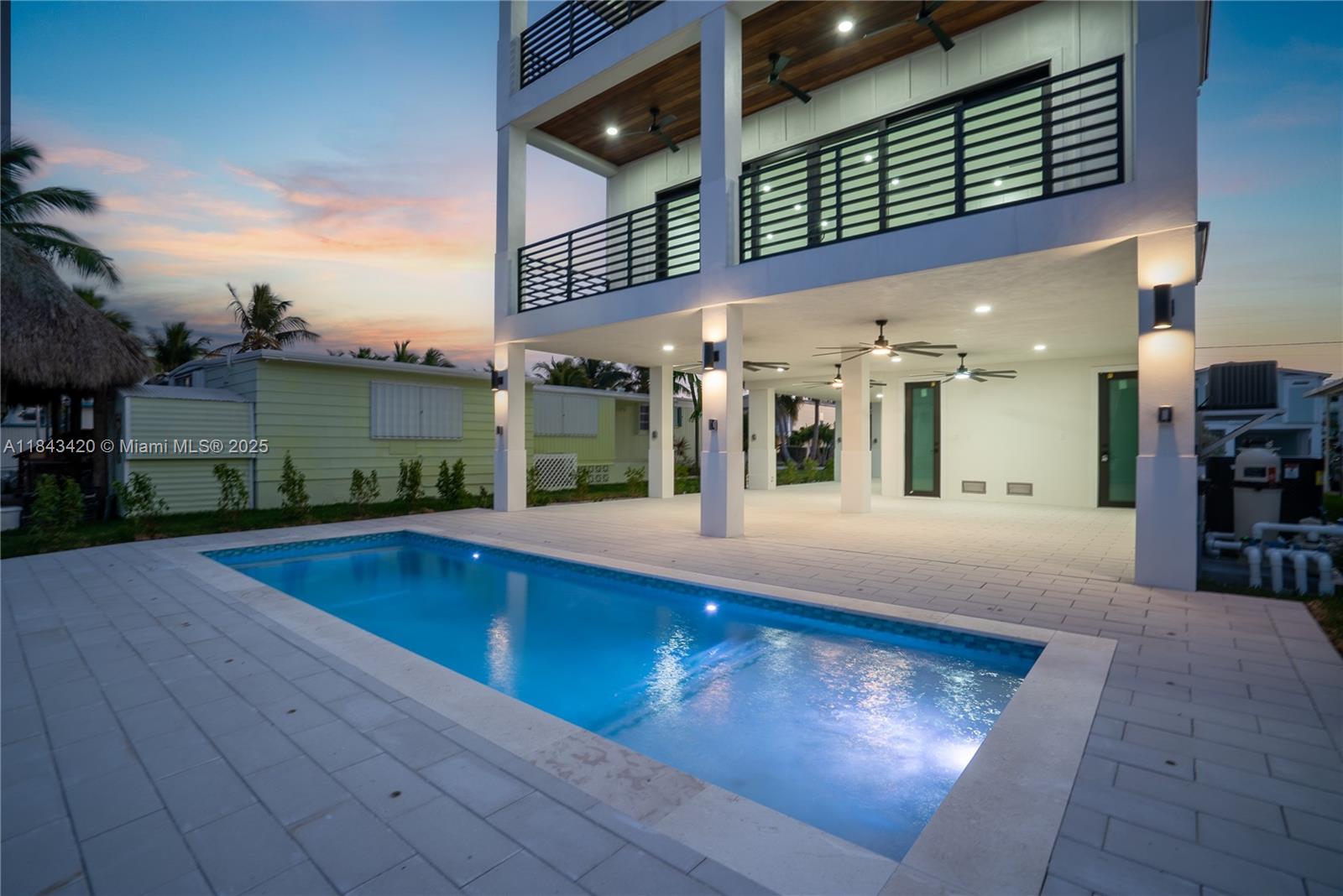 Welcome to the perfect coastal retreat in the heart of Key Largo. Located in The Harborage, this beautifully designed new construction canal-front home features four spacious bedrooms, each with its own private bath and balcony, ensuring everyone enjoys their own slice of paradise. The covered entryway invites you in, while an elevator makes it easy to navigate all levels of this inviting abode. With a strong 20K boat lift right outside your door, you'll have quick access to the crystal-clear canal and direct ocean access. Take a refreshing dip in the lovely concrete pool, sized at 26' x 10', complete with a convenient heater/chiller for year-round enjoyment. You'll love the ample covered outdoor spaces perfect for gathering with friends or soaking in the peaceful surroundings.