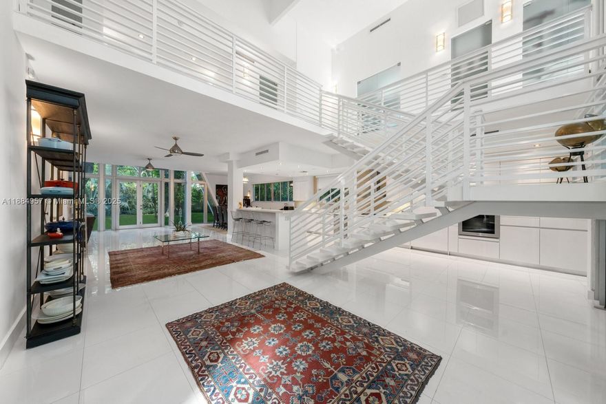 Designed by architect D.B. Lewis, this gated 2017 contemporary home in Coconut Grove offers a spacious layout ideal for entertaining. A dramatic three-story atrium greets you on entry, anchored by two mature oak trees. The lower level features a seamless indoor-outdoor flow and a chef’s kitchen with a gas Gaggenau cooktop and Miele and Viking appliances. Five en-suite bedrooms include a private primary wing with lounge, spa-style bath, and windowed walk-in closet. A 1-car air-conditioned garage and driveway space for three more vehicles add convenience. The rooftop retreat boasts a pool, gazebo, and cabana bath.
