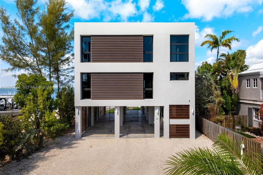 Modern bayfront residence in Key Largo, where minimalist architecture meets the natural beauty of the Florida Keys just 45 minutes from Miami. Designed by internationally acclaimed firm Resolution: 4 Architecture, whose work has been featured in Dwell, The Wall Street Journal, Architectural Record, and exhibited at MOMA, this architecturally significant waterfront home reflects a thoughtful balance of simplicity, light, and connection to nature. Constructed with ICF block and reinforced steel, the residence offers exceptional structural integrity and storm resilience while maintaining a sleek, low-profile form that complements its bayfront setting. Inside, the home embraces a refined minimalist aesthetic where clean lines, open volumes, and natural materials allow the landscape and water views to take center stage. Thoughtful design prioritizes both form and function, with extensive built-in storage and floating wardrobe systems that maintain the home's sleek architectural lines while providing exceptional usability. An open-concept floor plan centers around a chef's kitchen that flows seamlessly into the living and dining areas while maintaining uninterrupted bayfront views. Bayfront dockage with approximately six feet of controlling water depth to the seawall provides excellent boating access to Florida Bay and the Atlantic Ocean. Two boat lifts and generous dockage accommodate multiple vessels.