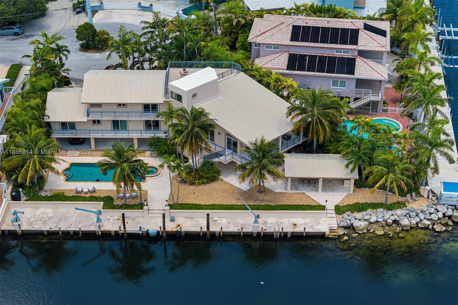 A Waterfront Masterpiece — 166 feet of pristine canal frontage, resort-style pool, and a massive owner's suite define this one-of-a-kind residence. Beautiful and spacious 3-story waterfront residence offering an impressive 166 feet of canal frontage with direct access the ocean. Designed for comfort and entertaining, this home blends elegant interiors with resort-style outdoor living. Inside, the main living area boasts soaring ceilings, natural light, and balconies that frame tranquil water views from every room. The open kitchen features custom wood cabinetry, stainless steel appliances, granite countertops, and an expansive breakfast bar that flows into the great room and dining space. Elegant stone flooring and quality finishes throughout.