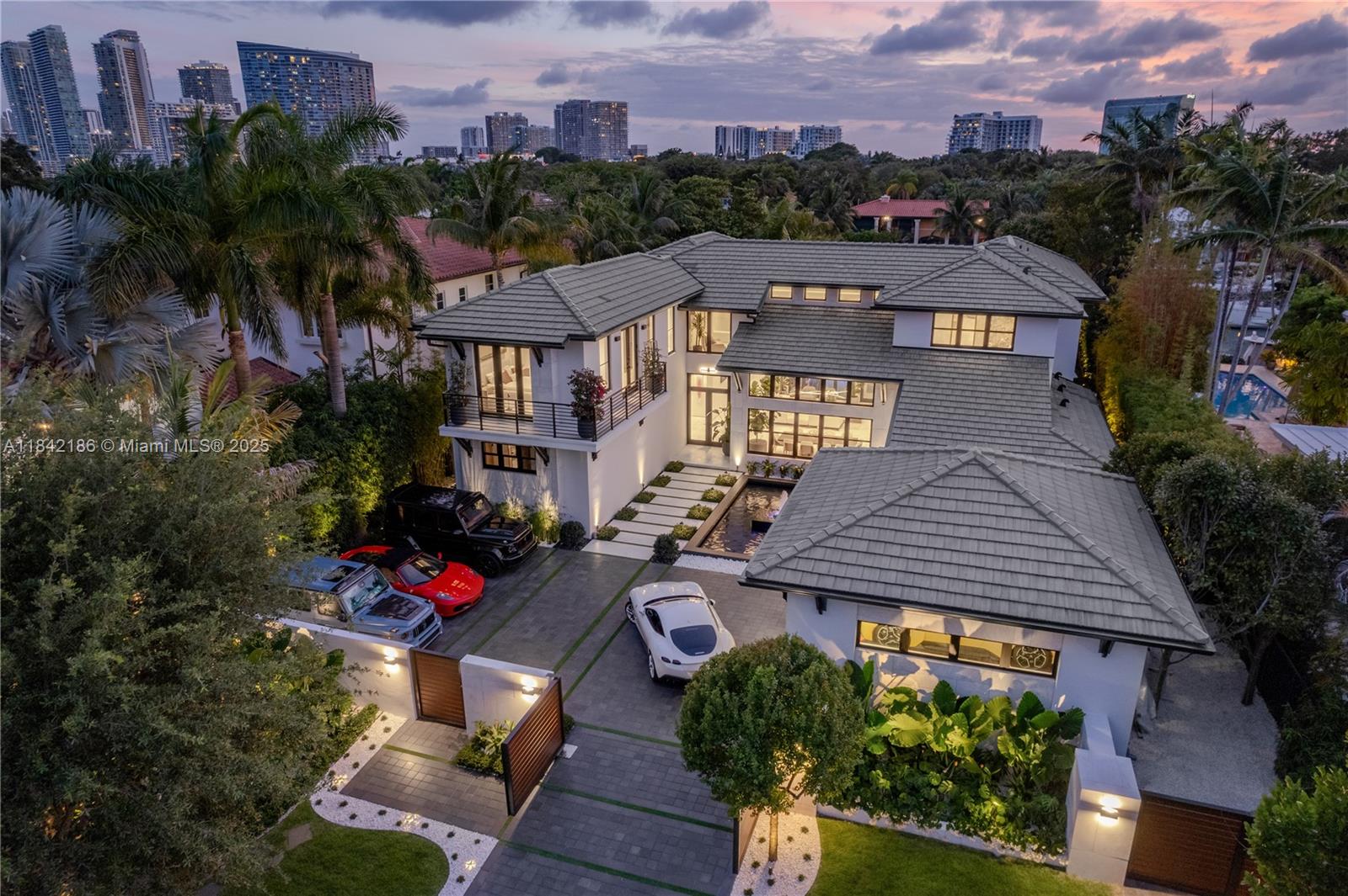 CASA EXUMAS – A Boater's Dream and a true Miami lifestyle experience. Nestled in the exclusive, gated
community of Bay Point, this luxurious, modern tropical waterfront residence offers approx. 85 ft of water
frontage, a private dock and direct access to Biscayne Bay. Enjoy high-end finishes, including spacious living
room with 25-foot ceilings, sleek fireplace, formal dining room with wine cellar, family room, & gourmet kitchen.
Six generous bedrooms feature private bathrooms and walk-in closets, including office and maid's quarters.
Exteriors include a double-height, air-conditioned 3-car garage with car lift, 5-car motor court, infinity-edge pool,
jacuzzi, summer kitchen, Ipe wood deck surrounded by tropical landscaping. Smart home system & generator.
Private financing available.