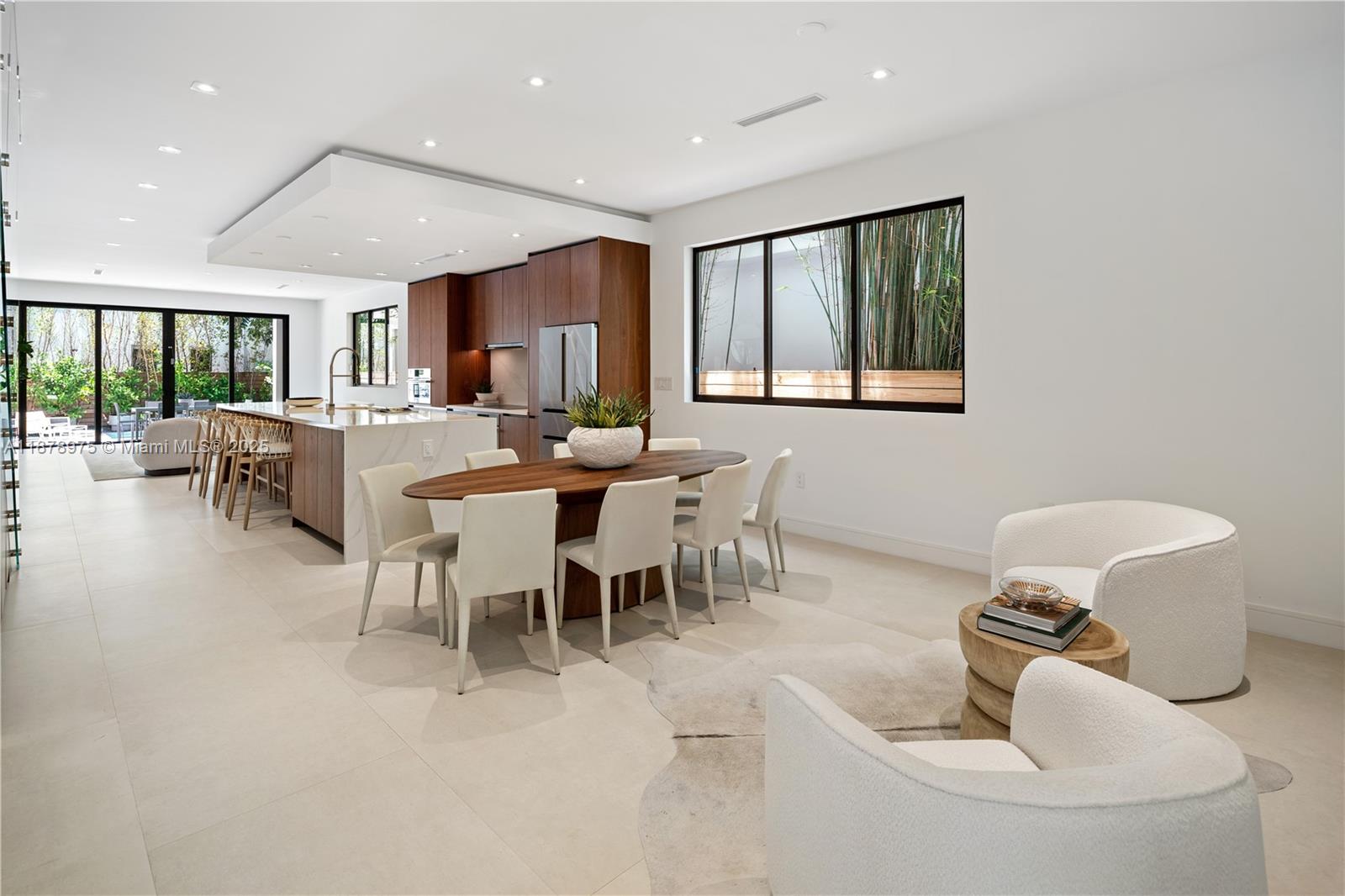 Built in 2022, this tri-level townhome blends contemporary design with the relaxed charm of Coconut Grove. Spanning 5,362 SF with 5 bedrooms and 5.5 baths, it offers bright interiors, volume ceilings, and refined finishes. The sleek European-style kitchen includes Thermador appliances, quartz countertops, and a large island with seating. Bedrooms feature spacious closets, with several opening to private balconies with lovely views. The primary suite is filled with light, showcasing floor-to-ceiling windows, a custom walk-in closet, and a luxurious bathroom with soaking tub and rain shower. Outside, enjoy the private garden, pool, and summer kitchen—perfect for relaxing or entertaining. Ideally located near Coconut Grove’s dining, shops, and top-rated schools.