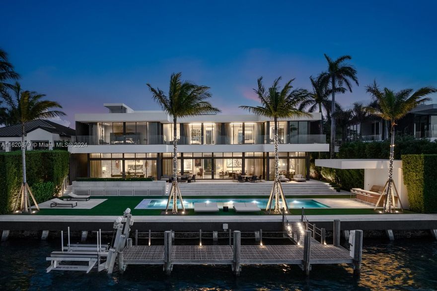 Experience the pinnacle of elegance and design on exclusive, guard-gated Hibiscus Island. This 12,322 SF masterpiece, set on a 21,000 SF lot with 120 feet of waterfront, is a contemporary homage to the French urban palace, Hôtel Particulier, blending elegance and modernity seamlessly. Designed by award-winning Touzet Studio, with interiors by Linda Zarifi and landscaping by Enea Garden Design, this smart home unites international French design with sleek Miami style. Luxurious features include Blue de Savoie marble, a gym with a steam room & yoga terrace, a custom Swiss kitchen, service wing with a staff apartment, a 50-foot heated pool, private dock, and a rooftop oasis complete with a spa & outdoor shower. This exquisite estate offers unmatched sophistication and comfort.