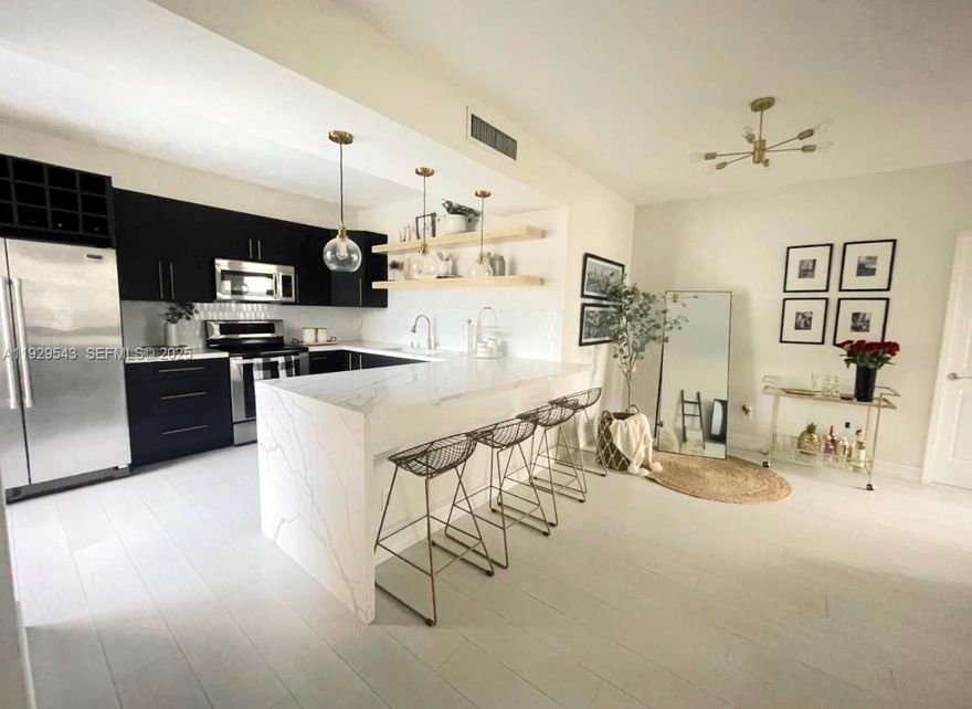 Beautifully updated first floor residence located in a gated community with guard entry, community pool, and ample guest parking. This light filled home features a stunning modern kitchen with sleek cabinetry, stainless steel appliances, and a quartz waterfall island with designer pendant lighting, opening to spacious living and dining areas. The primary suite offers a large walk in closet and a beautifully renovated bathroom with glass enclosed shower, while the secondary bathroom features updated finishes and a full tub. Enjoy indoor outdoor living with a private screened back patio and a welcoming front courtyard entry. Additional highlights include a separate laundry room, water included in the rent, and a well maintained community conveniently located near shopping, dining, A rated schools and major highways. Available after 1/31/2026.