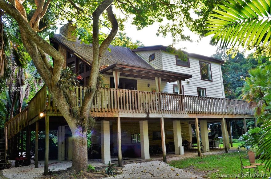 One of a kind, beautiful, well kept house., 20' ceilings, gorgeous fireplace, 1,000 s/f wraparound deck. 1/4 acre pond, 1.3 acre lot can be divided. Great location! Live in a tropical paradise 15 minutes away from Downtown Miami, Aventura and the beaches.