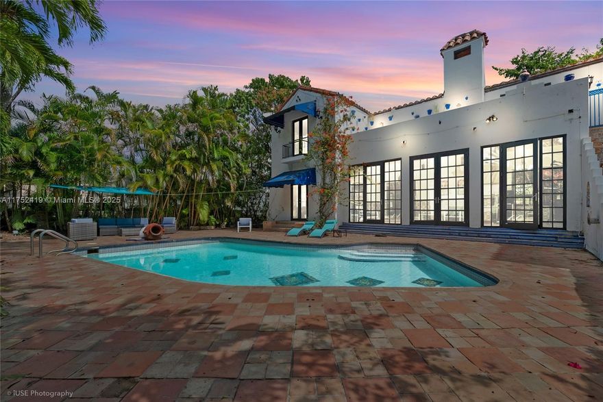 Experience timeless elegance in this stunning Coral Gables Mediterranean Villa, featuring exquisite Moroccan details on a coveted corner 1/2 acre lot. A charming courtyard entry leads to sunroom w/ arched windows & tranquil fountain. The grand living room boasts soaring beamed ceilings, carved fireplace & adjoining formal dining room. Beautifully crafted wood-scroll staircase ascends to the master suite, complete w/ fireplace, rich wood floors & private terrace overlooking the sparkling pool & serene fountain. The enchanting carriage house/guest cottage have impact windows and doors. Lush landscaping, peaceful pond & charming gazebo complete this architectural masterpiece, originally designed by renowned architect Martin Luther Hampton.  Walking distance to Granada Golf Course & tennis.