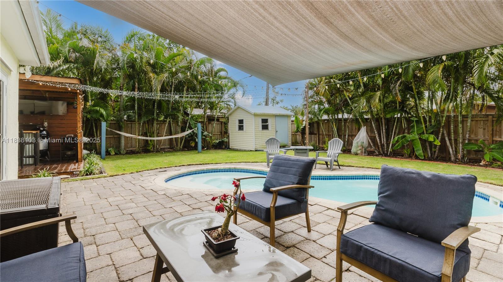 Perfect blend of comfort, charm, and waterfront living in this beautifully updated 2-bedroom, 1-bath POOL home with versatile extra room easily serves as a THIRD BEDROOM or home office. Situated along a quiet canal, this inviting home features restored terrazzo floors, Corian countertops, and new impact windows throughout. A . Recent improvements include a 2020 main roof, central AC with a mini split, and upgraded insulation for energy efficiency. Step outside to your private backyard oasis—complete with a sparkling pool, lush Empire Zoysia sod, a custom outdoor bar, and an outdoor shower. Launch your kayak or paddleboard right from your front yard and embrace the best of South Florida living.