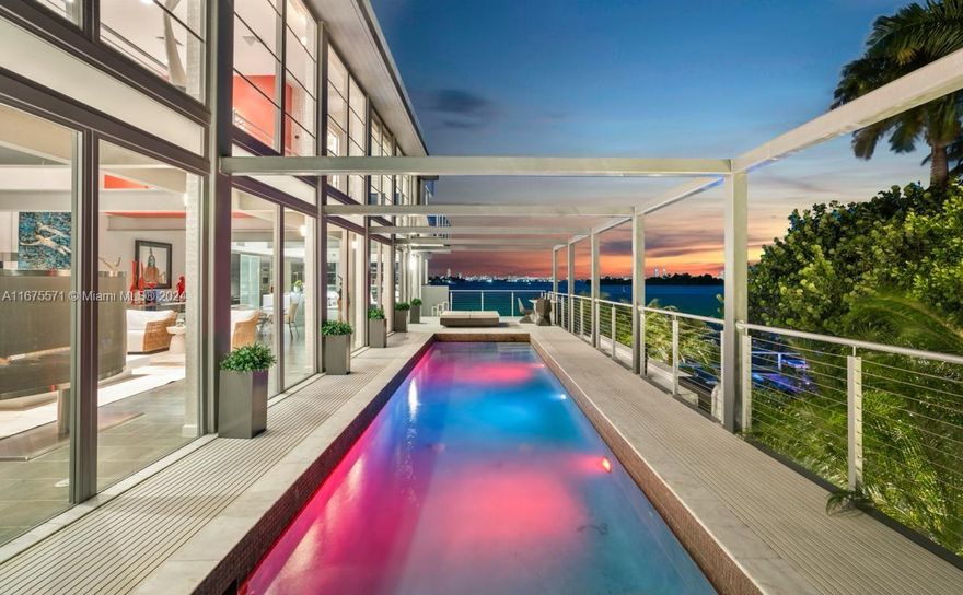 Introducing an exquisite modern glass masterpiece that transforms luxury waterfront living. Designed by the acclaimed architect Roney Mateu, this remarkable 4-bedroom, 5.5-bath estate includes a detached gym and cabana suite with breathtaking bay views. Impeccably landscaped grounds lead to a waterfront splash pool and statues throughout with 111 feet of water frontage. Soaring 20-foot ceilings in the living room open up to the suspended pool. Indulge in loft-style interiors, spa-inspired bathrooms, and unparalleled finishes. The sleek kitchen, featuring professional-grade appliances, is a chef’s haven. The primary suite boasts a private balcony, a lavish soaking tub overlooking Biscayne Bay, and a generous walk-in closet. Located on the double guard gated Belle Meade Isle