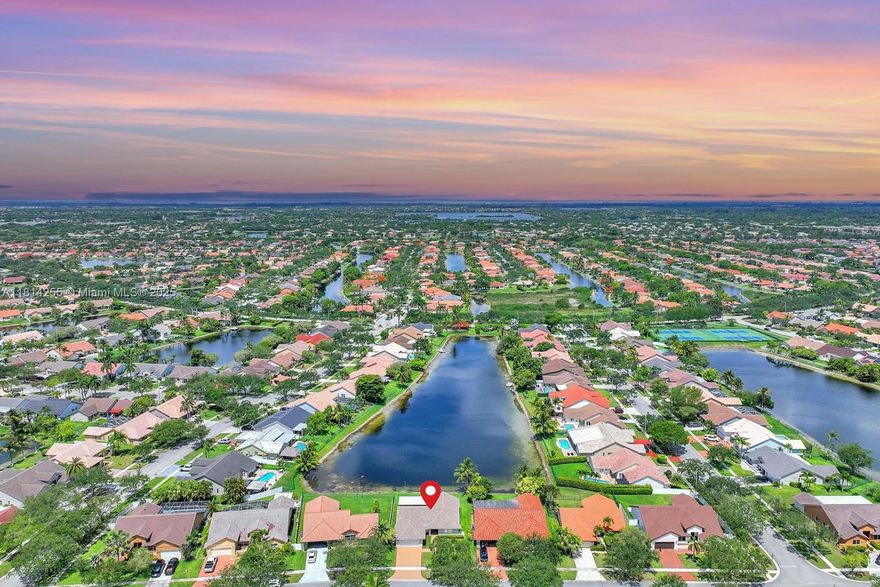 Exquisitely remodeled lakefront home in Spring Valley, Pembroke Pines. Welcome to this elegantly updated 3 bed, 2 bath home which was completely re-imagined. Home offers a perfect blend of modern upgrades for style and comfort with serene long water views. Chef's kitchen features a sleek design complete with stainless appliances, custom cabinetry, island, built-in Miele coffee maker & custom bar w wine and beverage fridges. Every surface of this home was thoughtfully updated to include: new roof, a/c, water heater, impact windows, doors & sliders flooring, appliances, baths, lighting, EV charger & much more. Enjoy outdoor living on the gorgeous covered patio/pergola overlooking the tranquil lake. Walk to Spring Valley park swim in the pool & play in the sports courts the community offers.