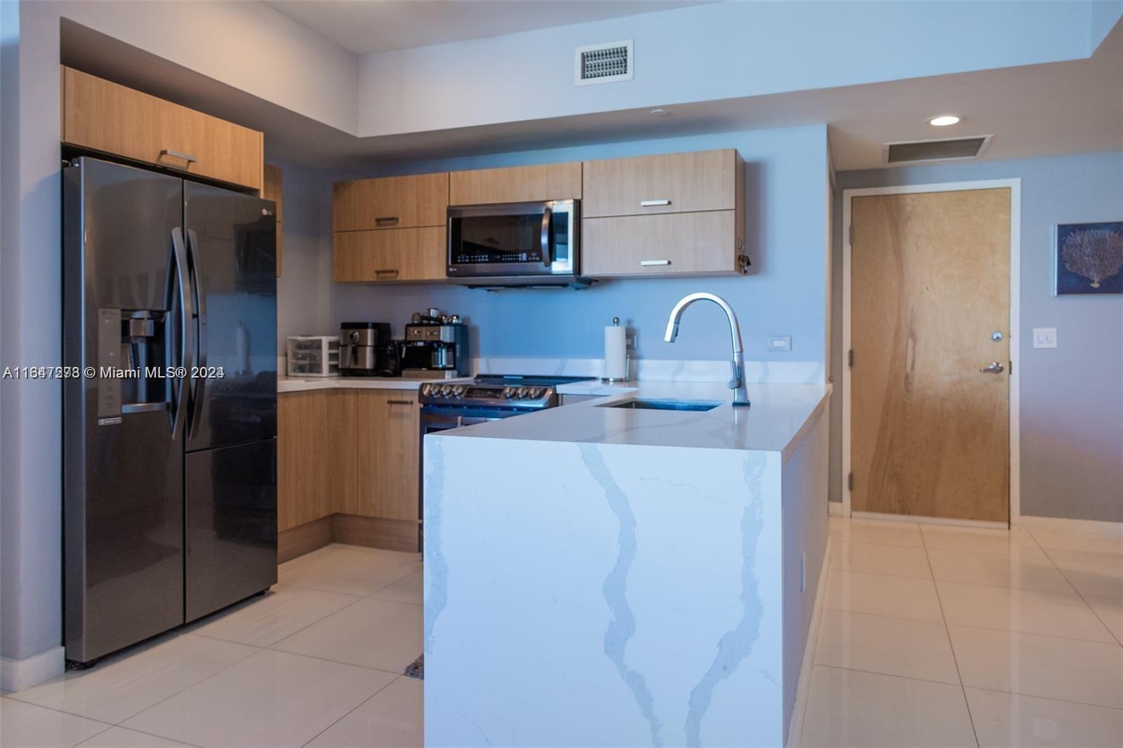 Discover the epitome of luxury in this fully furnished, turnkey 2 bed / 2 bath + den unit, showcasing breathtaking views of the Miami skyline and river. This stunning, completely upgraded split floorplan features a brand-new kitchen with quartz countertops, new appliances, and a full-capacity in-unit washer & dryer. Both bathrooms have been elegantly remodeled with glass shower doors, double vanities with floating sinks, bathroom fans, and a new tankless water heater. Enjoy the convenience of electronic shades on the main windows, blackout shades in the bedrooms, and custom built-in closets. Located in a prestigious high-rise with 24-hour concierge/security, pool, fitness center, business center, and valet. 1 parking space included. Agents please read broker remarks for showings
